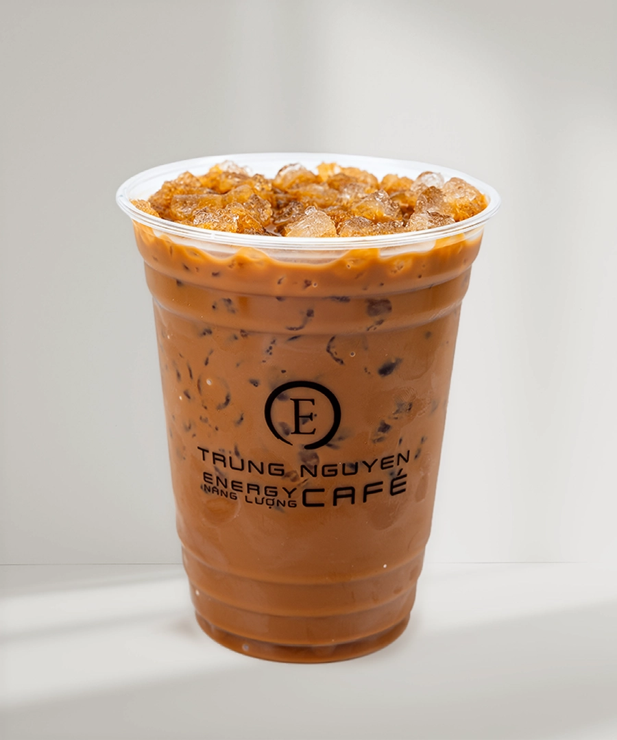 A clear plastic cup filled with Trung Nguyen iced coffee, showcasing the brand's logo