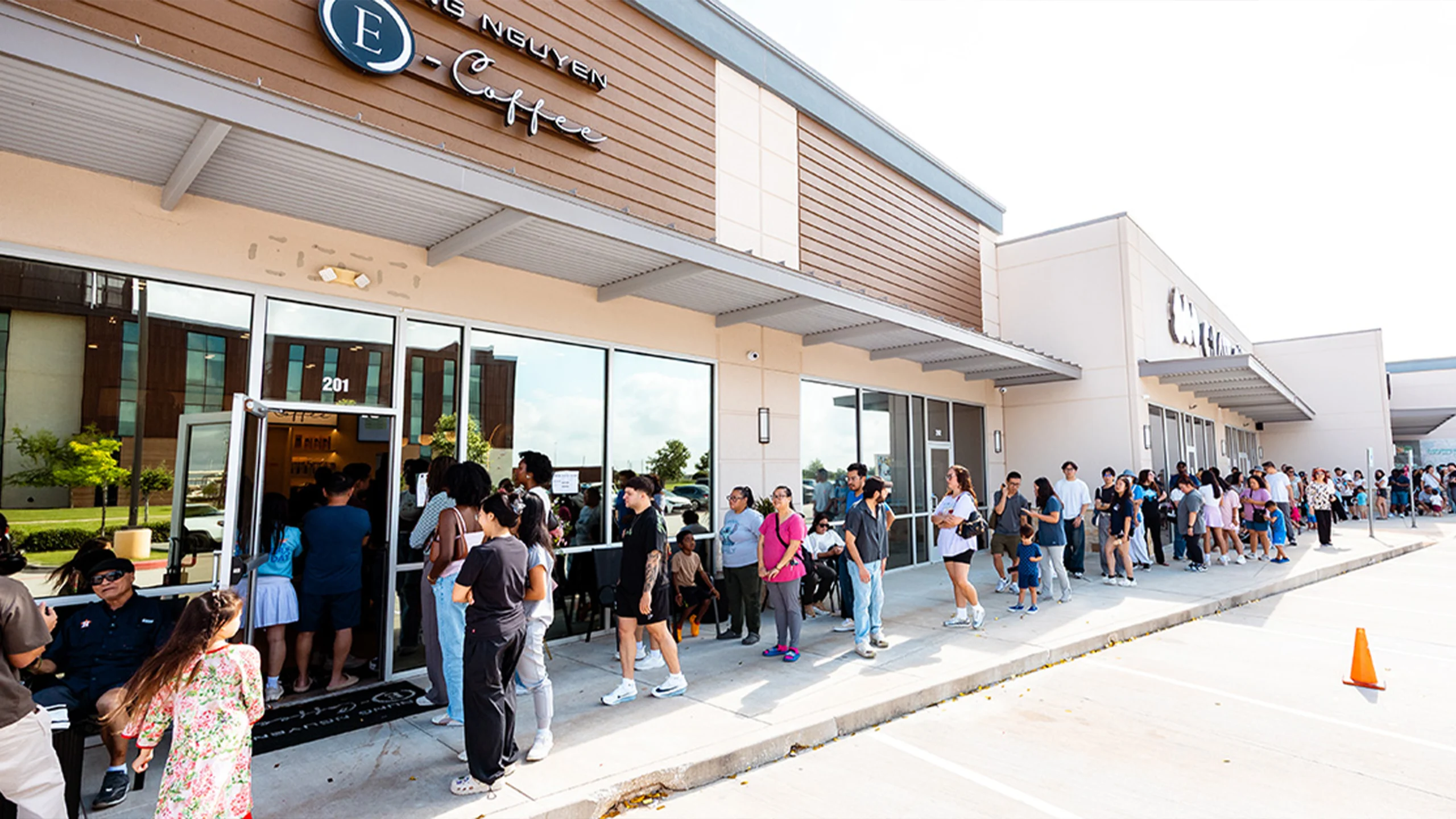 TNECIMAGE000016 Exterior view of the Trung Nguyên E-Coffee store in Houston, Texas, featuring a long line